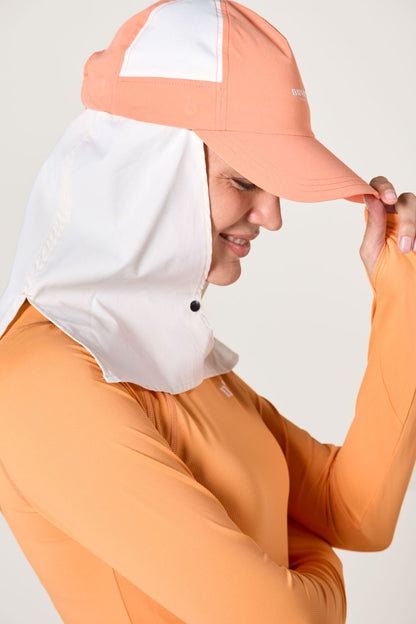 Femme portant une casquette anti-UV bicolore avec protection solaire, idéale pour activités extérieures.