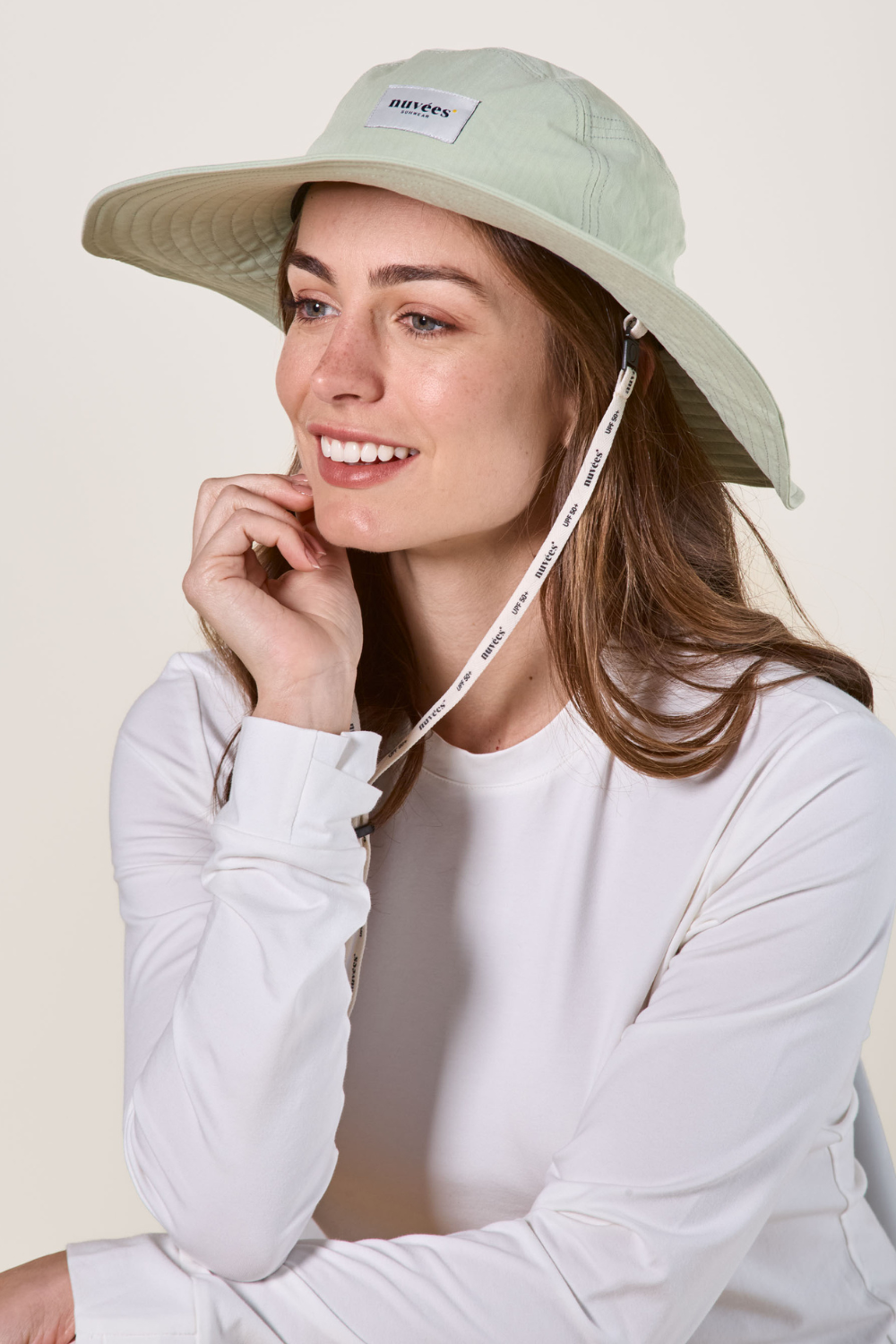 Femme portant un chapeau anti-UV vert, idéal pour la protection solaire lors des journées ensoleillées.