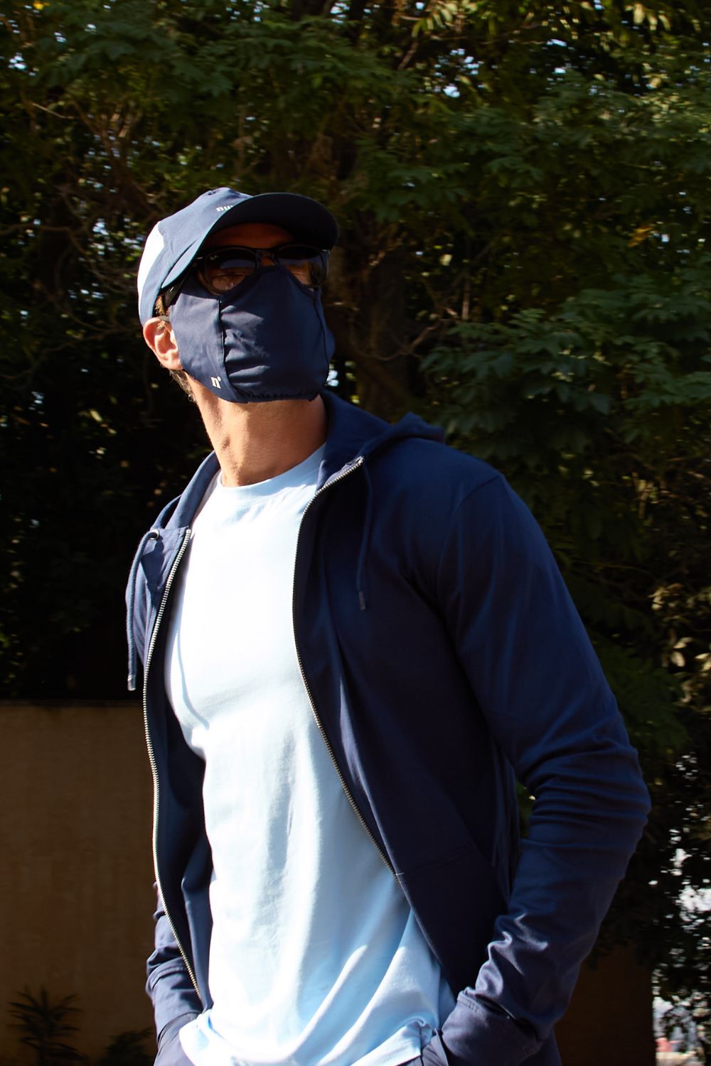 Mask anti-UV bleu pour homme, protection solaire UPF50+, porté avec un t-shirt léger lors d'une sortie en plein air.