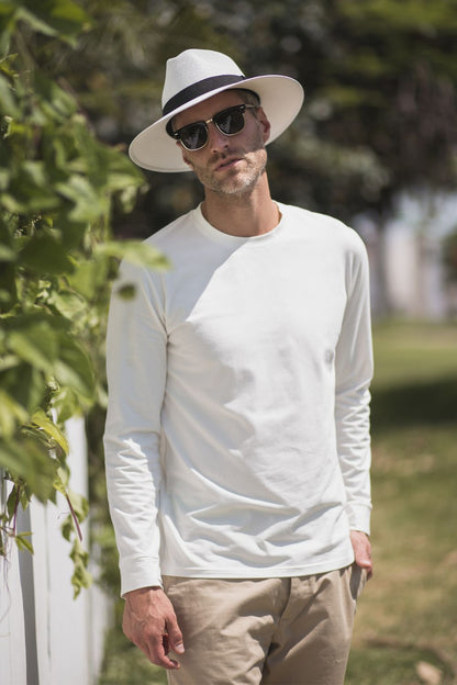 Homme portant un t-shirt anti-UV blanc à manches longues et chapeau, idéal pour la protection solaire UPF 50+.